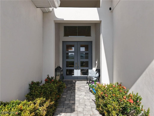 doorway to property featuring french doors and stucco siding