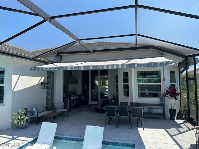 back of house with stucco siding, a patio area, a lanai, and an outdoor hangout area