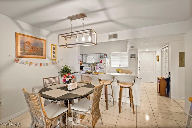 dining space featuring baseboards, visible vents, and light tile patterned flooring