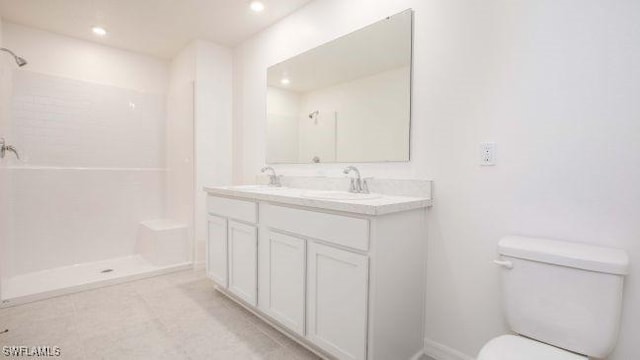 bathroom with toilet, double vanity, walk in shower, and a sink