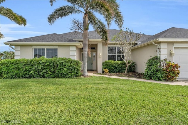 ranch-style home with a shingled roof, a front yard, an attached garage, and stucco siding