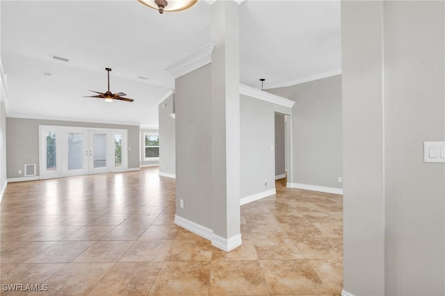 spare room with a ceiling fan, visible vents, baseboards, and crown molding