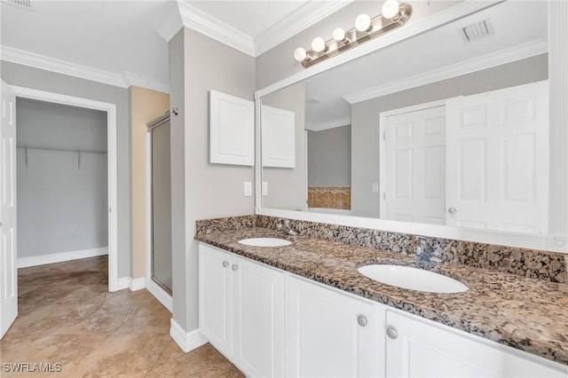 bathroom with baseboards, visible vents, crown molding, a shower stall, and a sink