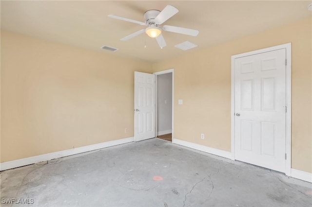 spare room featuring baseboards, unfinished concrete floors, visible vents, and ceiling fan