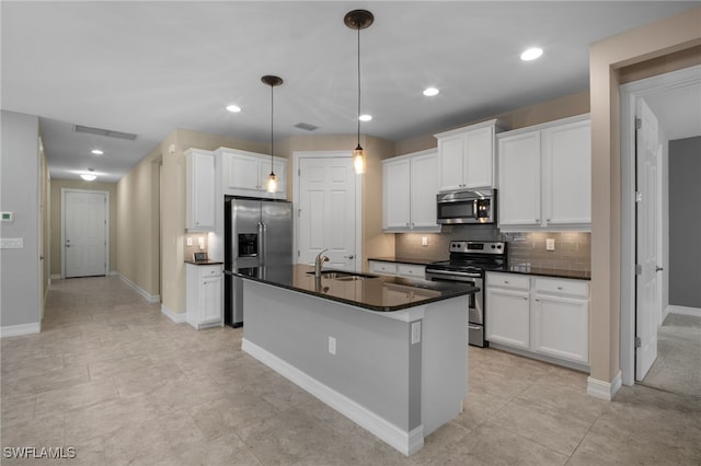 kitchen featuring visible vents, dark countertops, appliances with stainless steel finishes, a sink, and backsplash