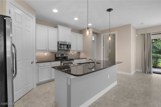 kitchen featuring appliances with stainless steel finishes, a sink, white cabinetry, and decorative backsplash