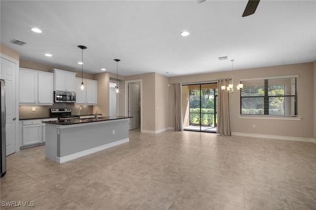 kitchen featuring visible vents, dark countertops, open floor plan, stainless steel appliances, and backsplash