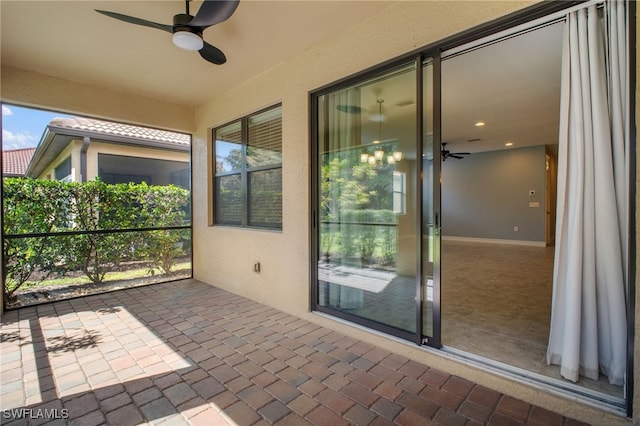 unfurnished sunroom featuring ceiling fan