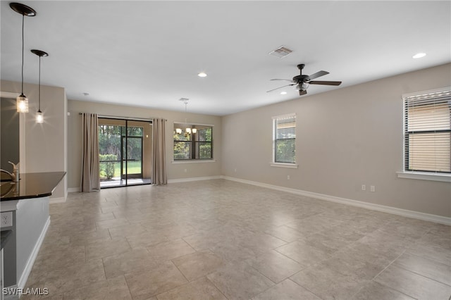 unfurnished room with baseboards, visible vents, and a wealth of natural light