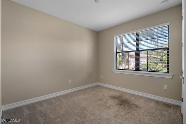 empty room with carpet and baseboards