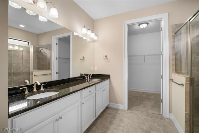 full bath featuring a sink, a walk in closet, and a shower stall