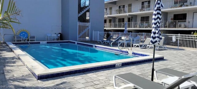 community pool with fence and a patio