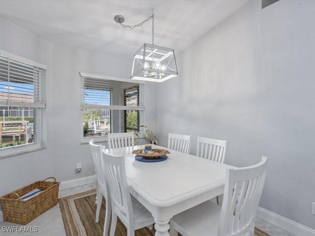 dining area featuring a notable chandelier, a wealth of natural light, and baseboards