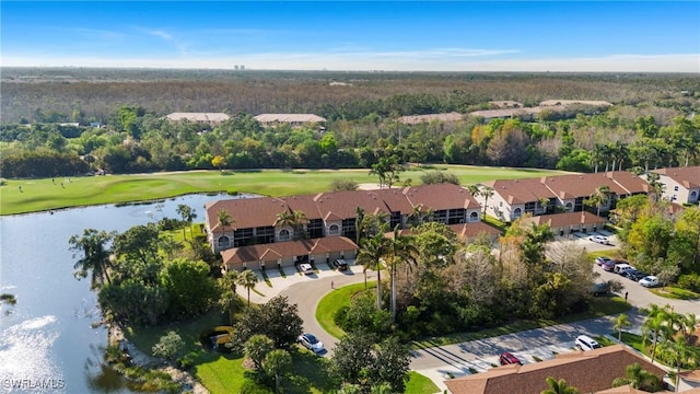 aerial view with view of golf course, a water view, and a forest view