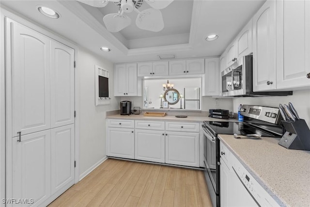 kitchen featuring light wood finished floors, ceiling fan, stainless steel appliances, white cabinetry, and a raised ceiling