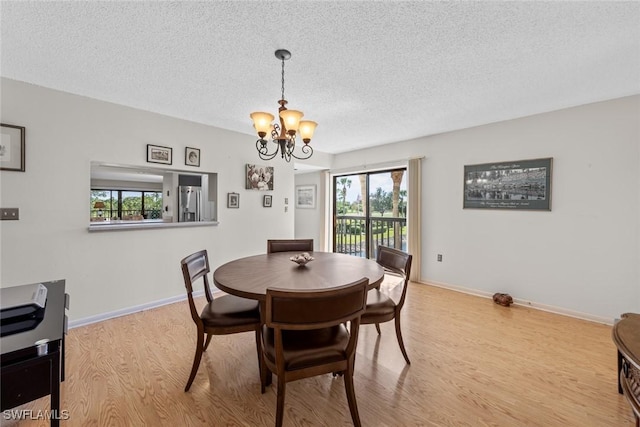 dining room with an inviting chandelier, wood finished floors, baseboards, and a textured ceiling