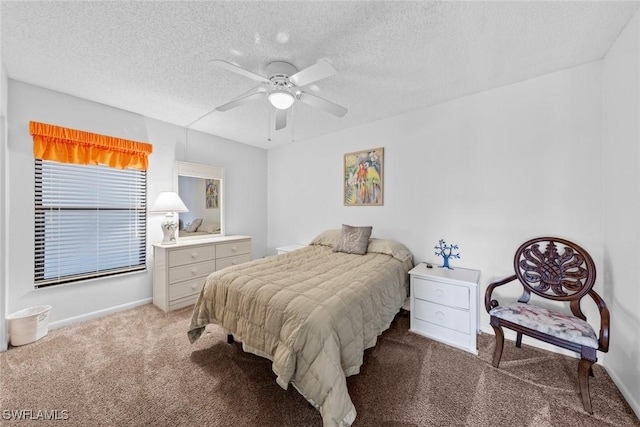 bedroom featuring baseboards, light colored carpet, a textured ceiling, and ceiling fan