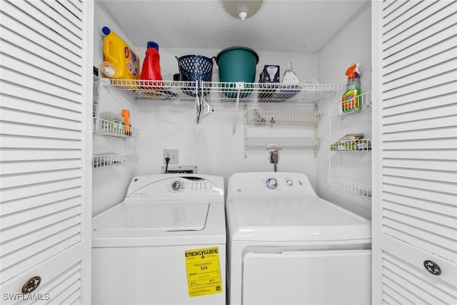 clothes washing area featuring a textured ceiling, independent washer and dryer, and laundry area