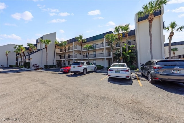 view of building exterior featuring a residential view and uncovered parking