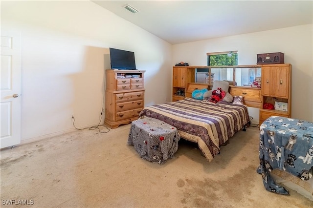 bedroom with carpet floors, visible vents, and vaulted ceiling