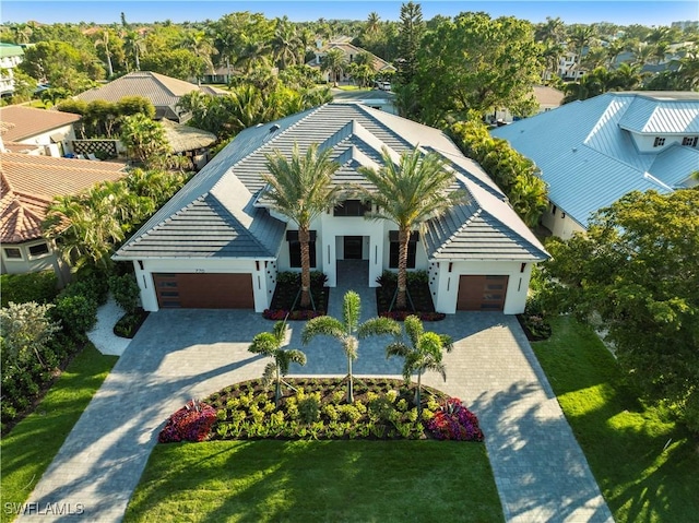 view of front of property with a garage, decorative driveway, a front yard, and a tile roof