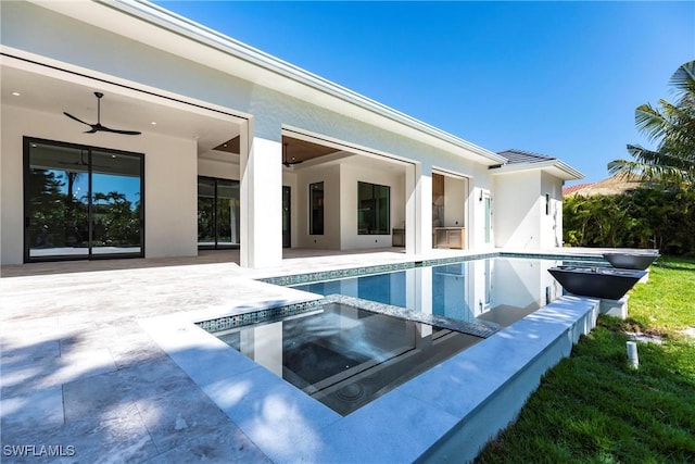 exterior space featuring a patio, ceiling fan, and an in ground hot tub