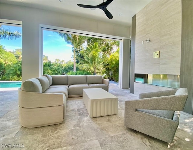 770 Port Side Dr, Naples, FL 34103 - living room featuring ceiling fan, light stone finish floors, and tile walls