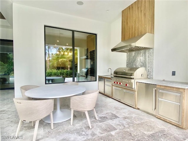770 Port Side Dr, Naples, FL 34103 - kitchen featuring wall chimney exhaust hood, stone finish flooring, and light countertops