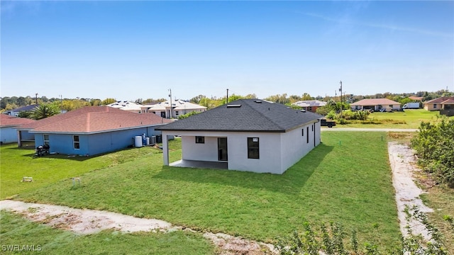 rear view of house with a yard and stucco siding