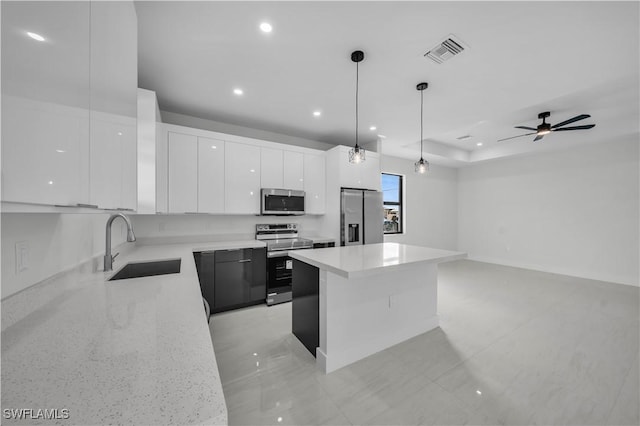 kitchen featuring visible vents, modern cabinets, appliances with stainless steel finishes, white cabinetry, and a sink