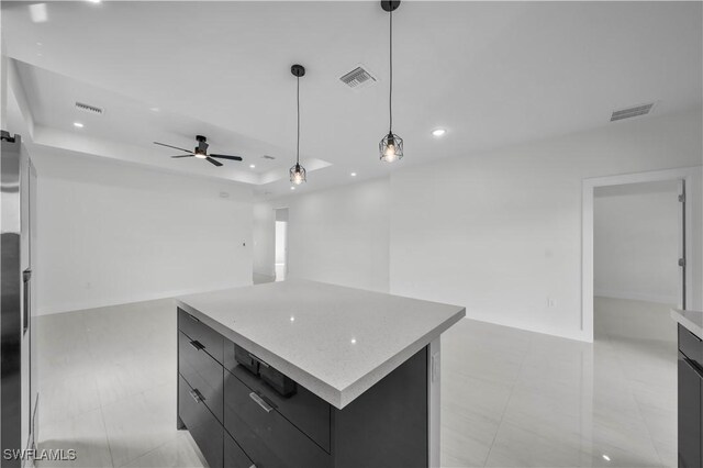 kitchen with modern cabinets, visible vents, a raised ceiling, and dark cabinets