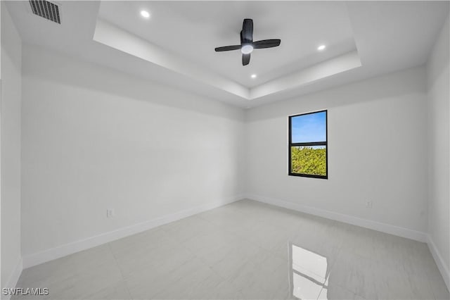 spare room with ceiling fan, recessed lighting, visible vents, baseboards, and a raised ceiling