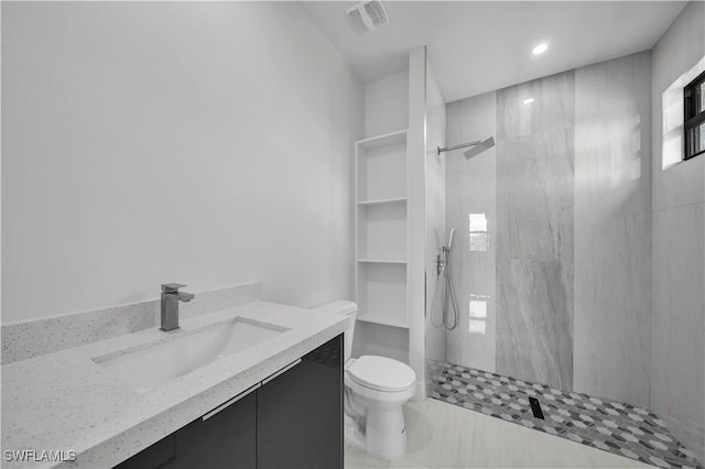 full bathroom featuring a walk in shower, visible vents, vanity, and toilet