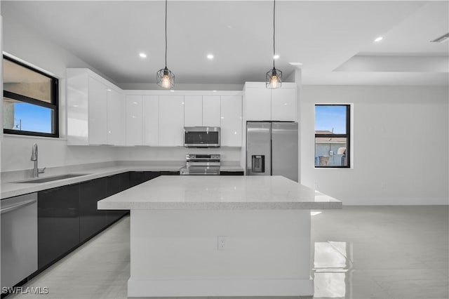 kitchen with a center island, stainless steel appliances, white cabinetry, a sink, and modern cabinets