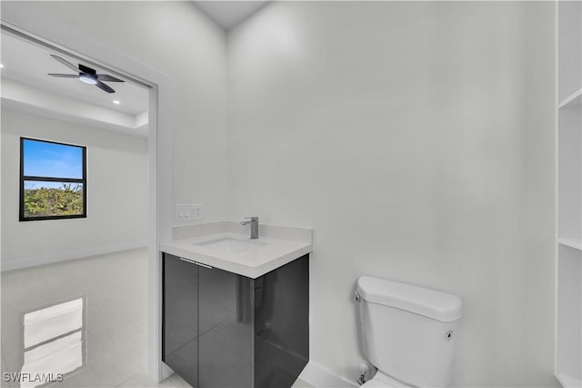 half bath with a ceiling fan, recessed lighting, a sink, and toilet