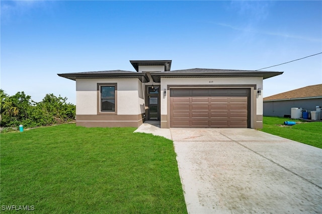 prairie-style home featuring a garage, driveway, a front lawn, and stucco siding