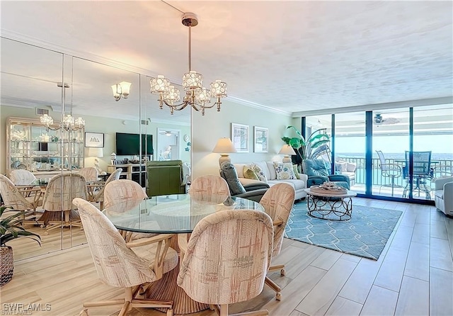 dining room with visible vents, a chandelier, a wall of windows, and crown molding