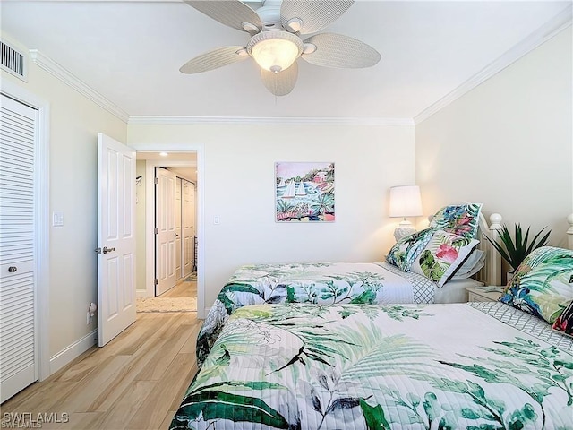 bedroom featuring ornamental molding, visible vents, light wood-style flooring, and baseboards