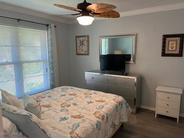 bedroom with baseboards, wood finished floors, a ceiling fan, and crown molding