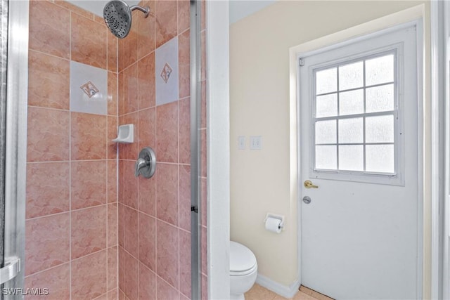 bathroom featuring a shower stall, toilet, and baseboards