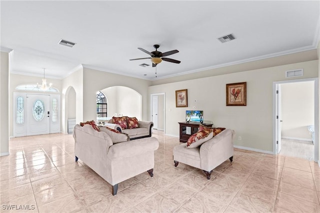 living area with ornamental molding, arched walkways, visible vents, and baseboards