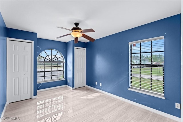 spare room featuring a ceiling fan and baseboards