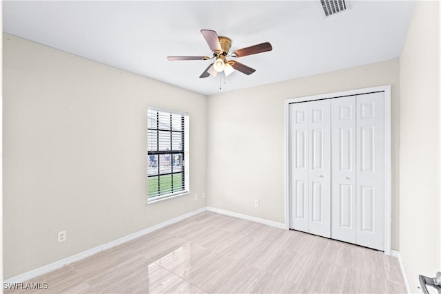 unfurnished bedroom featuring a ceiling fan, a closet, visible vents, and baseboards