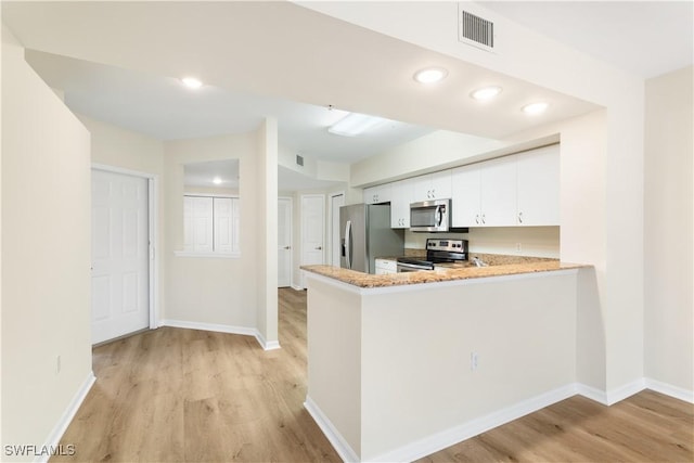 kitchen featuring visible vents, baseboards, light wood-style floors, white cabinets, and appliances with stainless steel finishes