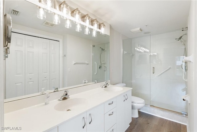 full bath featuring a stall shower, a sink, and wood finished floors