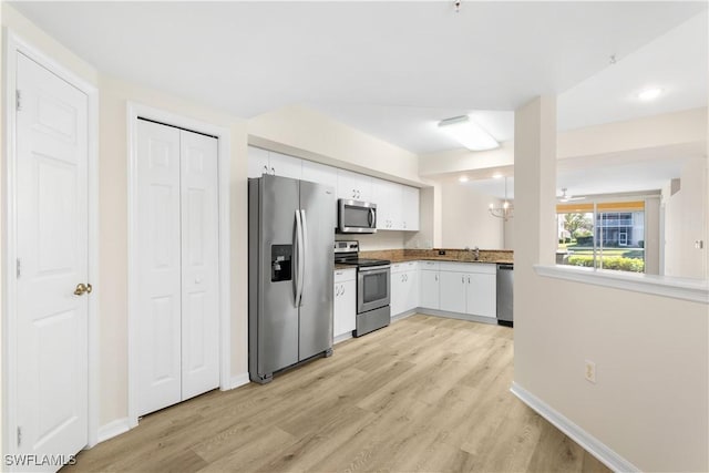 kitchen with stainless steel appliances, light wood-type flooring, a sink, and white cabinetry