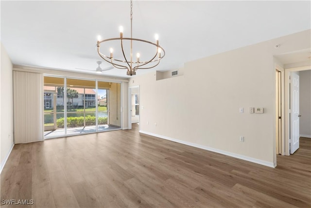 spare room with visible vents, baseboards, and wood finished floors