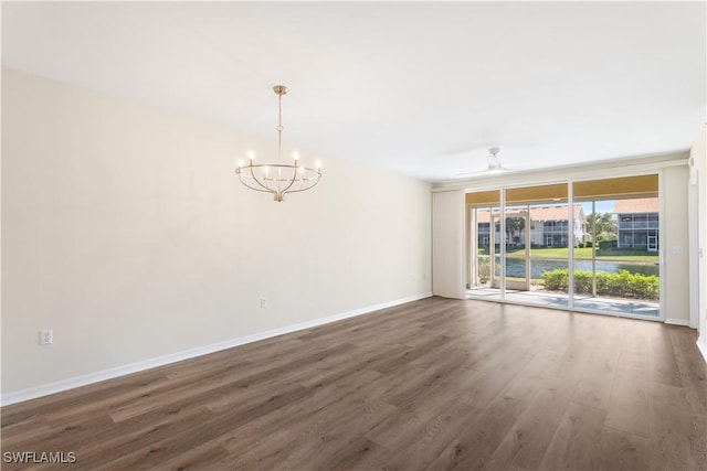 unfurnished room featuring ceiling fan with notable chandelier, baseboards, and wood finished floors