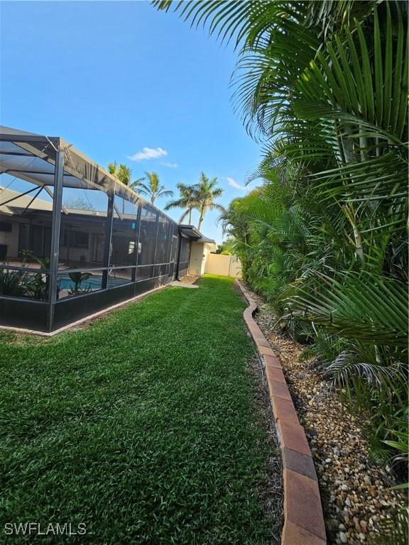 6048 Birnam Wood Ln, Fort Myers, FL 33908 - view of yard with glass enclosure, fence, and an outdoor pool