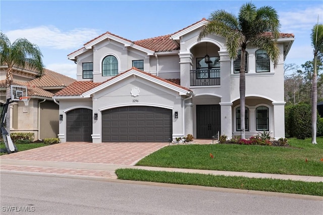 mediterranean / spanish-style house featuring a balcony, stucco siding, a tiled roof, and a front yard